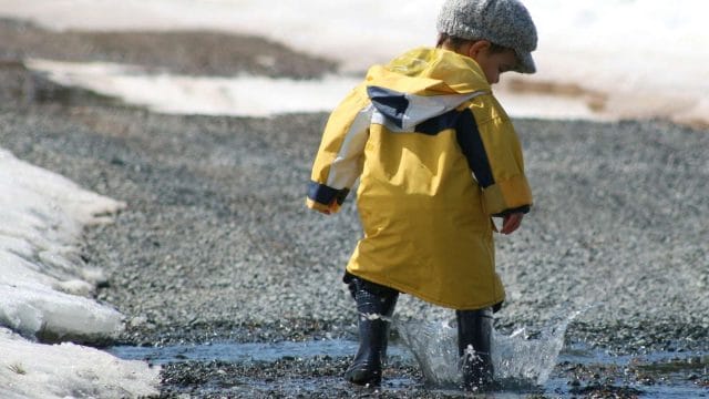 photo of a kid splashing in a puddle